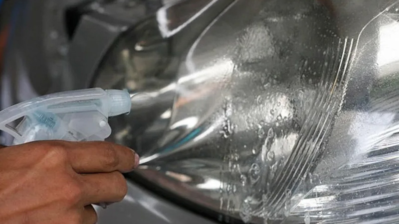 Xịt một lớp dung dịch phun xịt sau đó lau kính xe